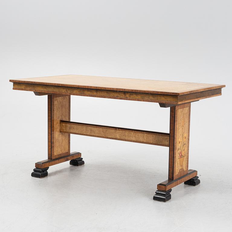 A 1930's birch and rosewood-veneered dining table.