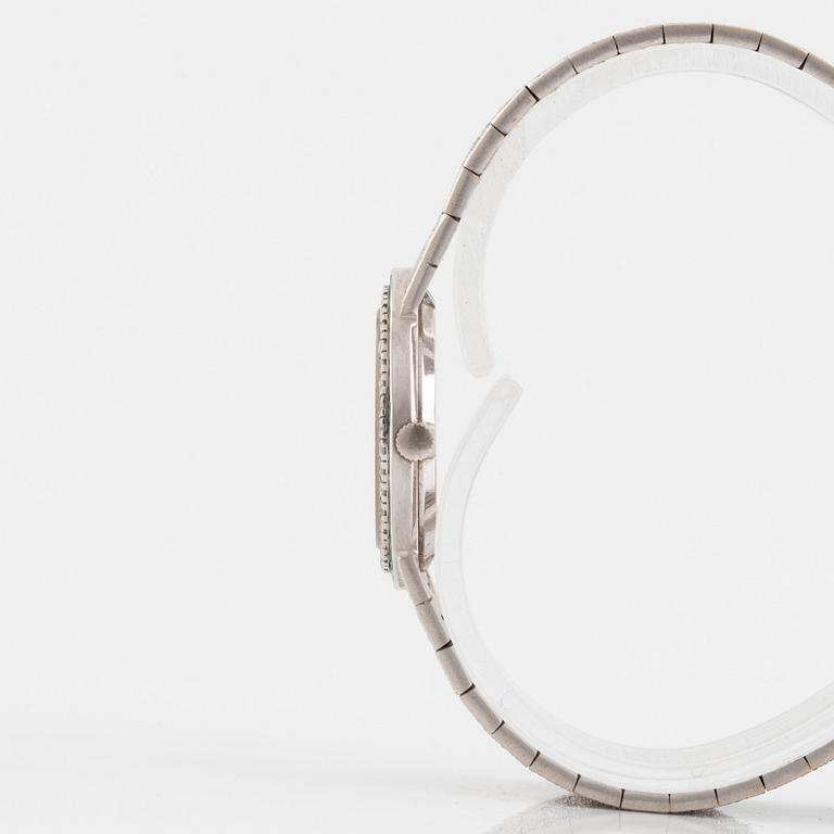 A Piaget 18K white gold wrist watch set with round brilliant-cut diamonds and step-cut emeralds.