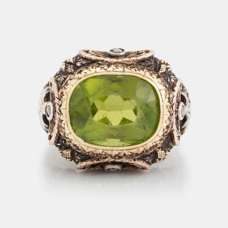 A silver and gold ring set with a faceted peridot and rose-cut diamonds.