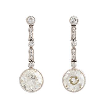 493. A pair of platinum earrings with two larger old-cut diamonds.