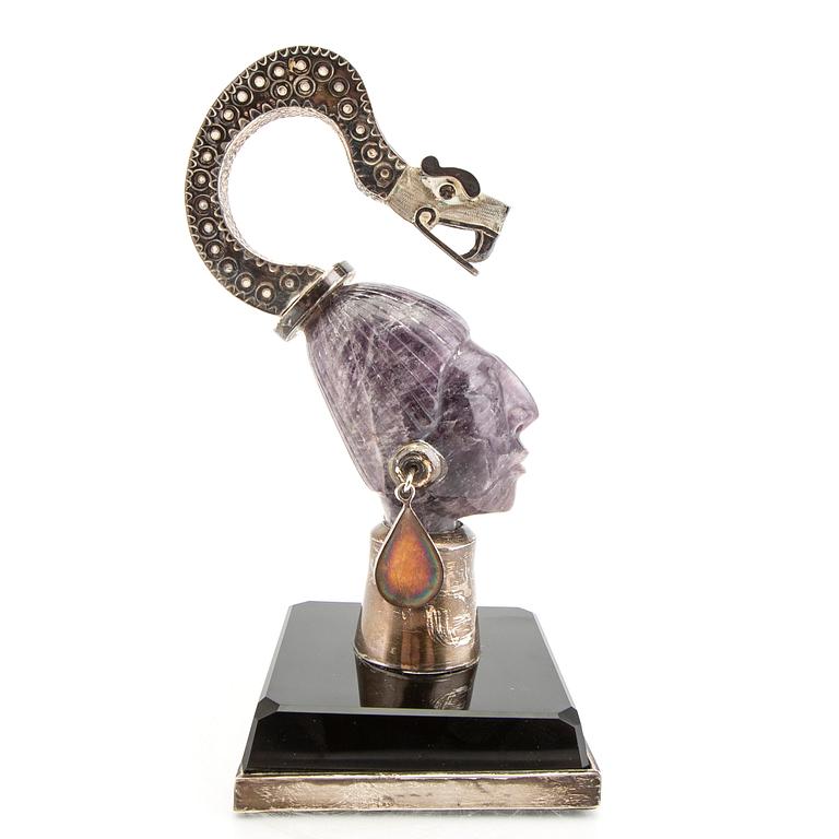 An amethyst and silver sculpture in the shape of a womans face with snake on her head, Mexico.