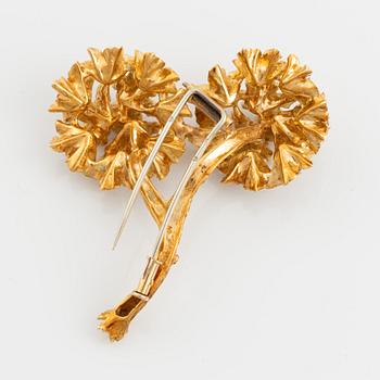 An 18K gold brooch set with round brilliant-cut diamonds.