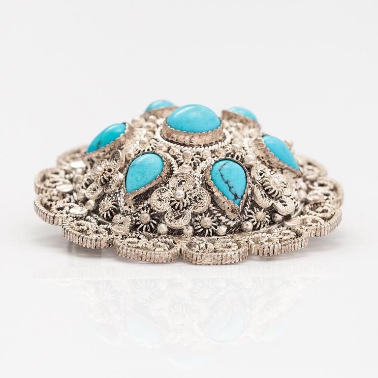 A silver bracelet and ring with turquoises. China.