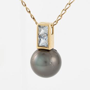 Pendant in 18K gold with a cultured pearl and faceted white stones.