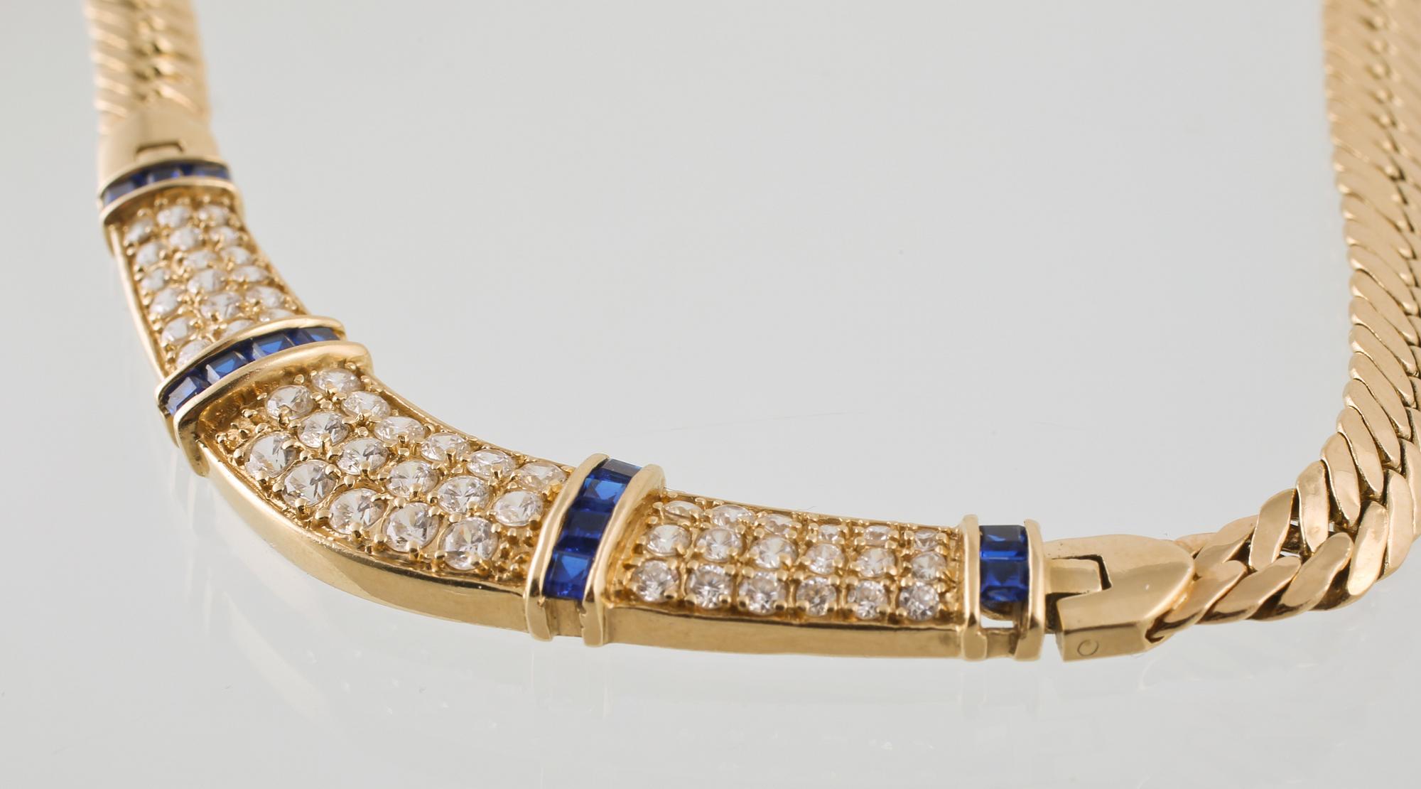 COLLIER, 14K guld med briljantslipade syntetiska vita stenar samt fasettslipade syntetiska blå safirer. Vikt 16,9 gram.