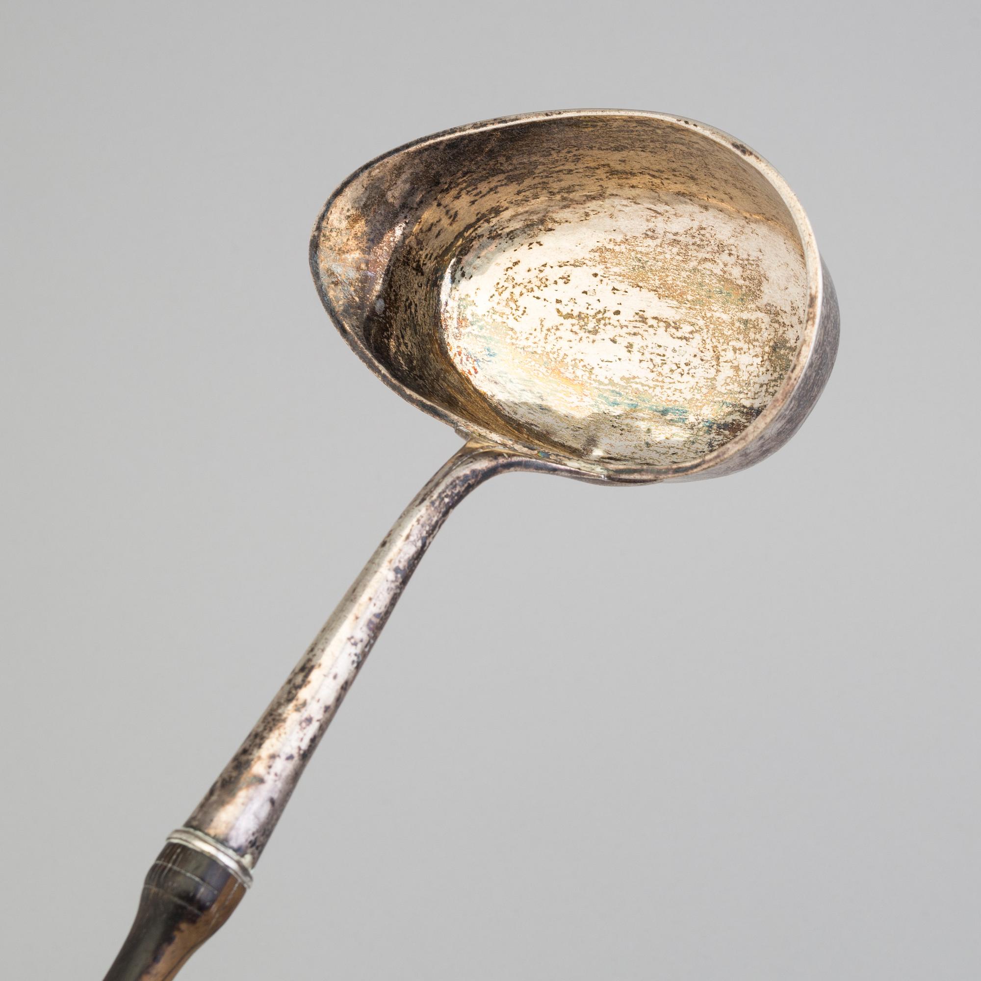 A 19th century silver soup and a sauce ladle with wooden handles.