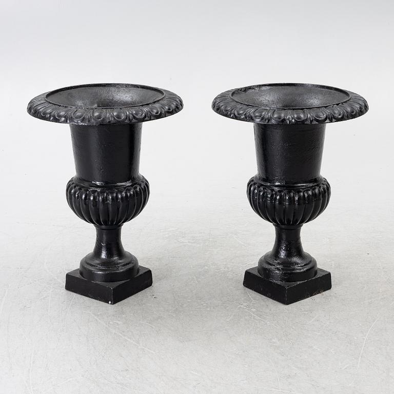 A pair of cast iron garden urns, 20th century.