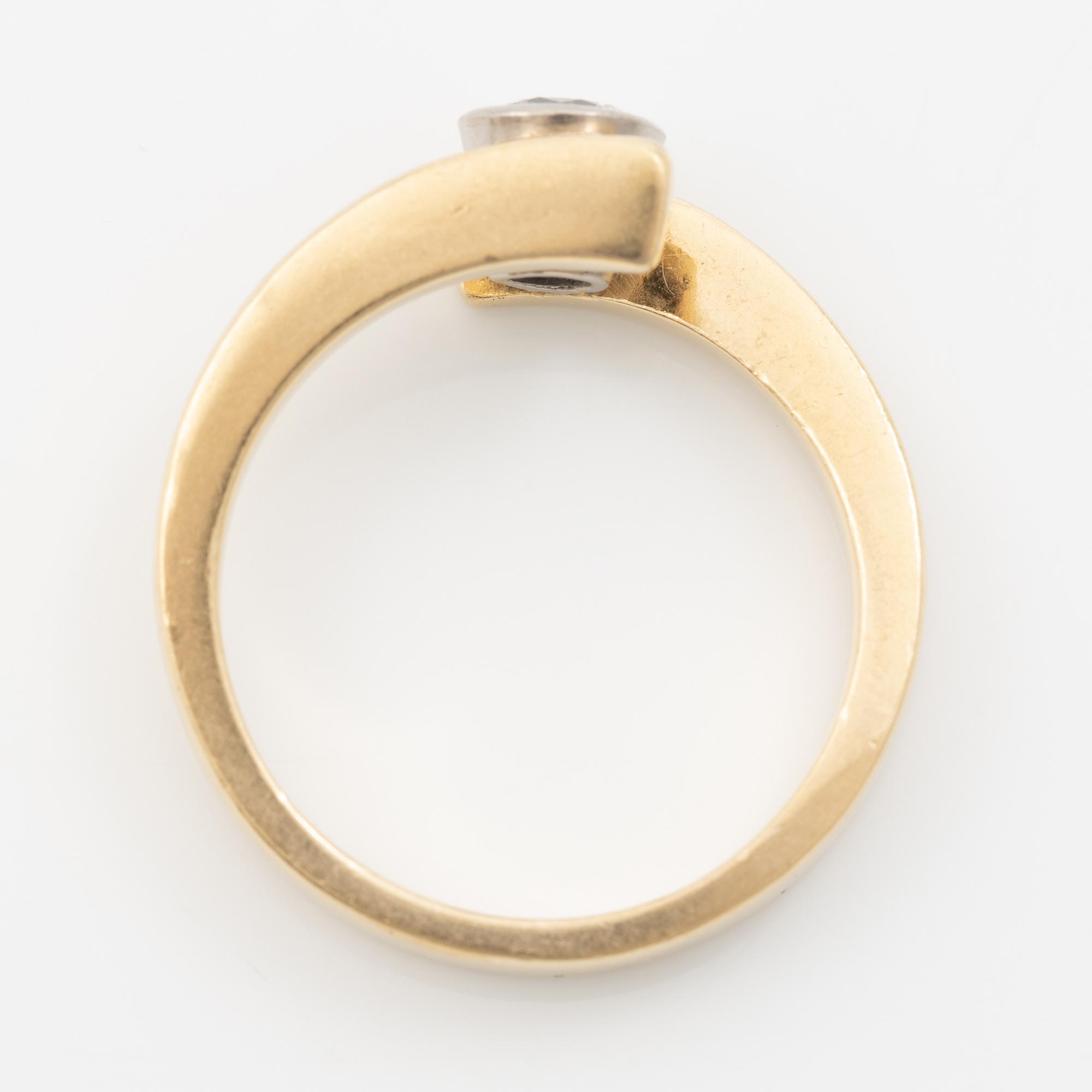 18K gold ring with a round brilliant-cut diamond.