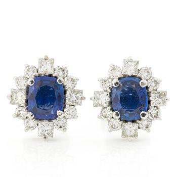 A pair of 14K gold earrings with faceted sapphires and round brilliant- and princess-cut diamonds.