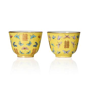 A pair of yellow glazed double happiness cups with butterflies, Qing dynasty, with Tongzhis four character mark to base.