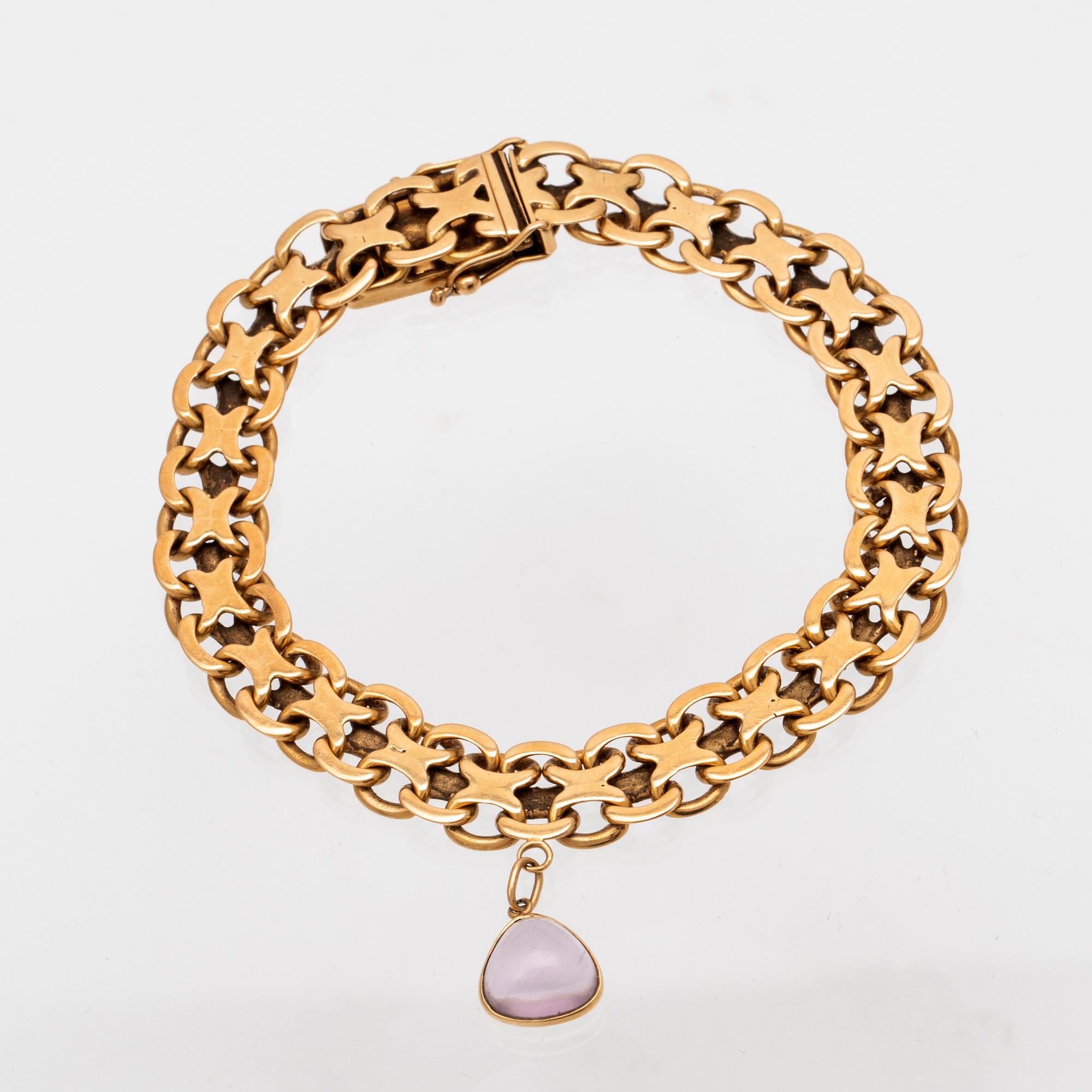 An 18K gold x-link bracelet with cabochon cut amethyst.