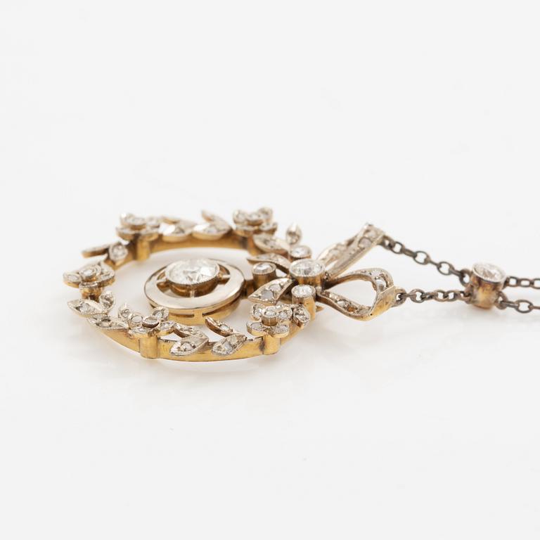 Hängsmycke 18K guld och silver i form av rosettkrans med gammal-och rosenslipade diamanter, omkring sekelskiftet 1900.