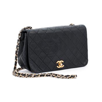 CHANEL, a black leather quilted purse with shoulder strap.