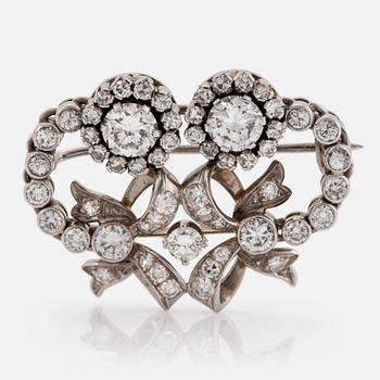 930. An 18K white gold brooch set with round brilliant- and eight-cut diamonds.