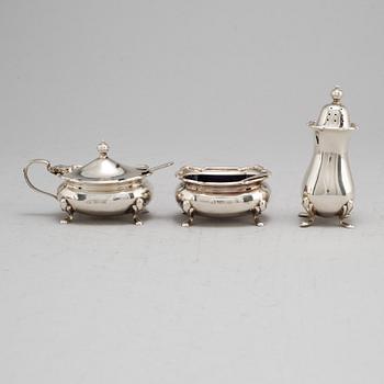 A silver salt cellar, peppershaker and mustard pot from Birmingham, England, 1961.