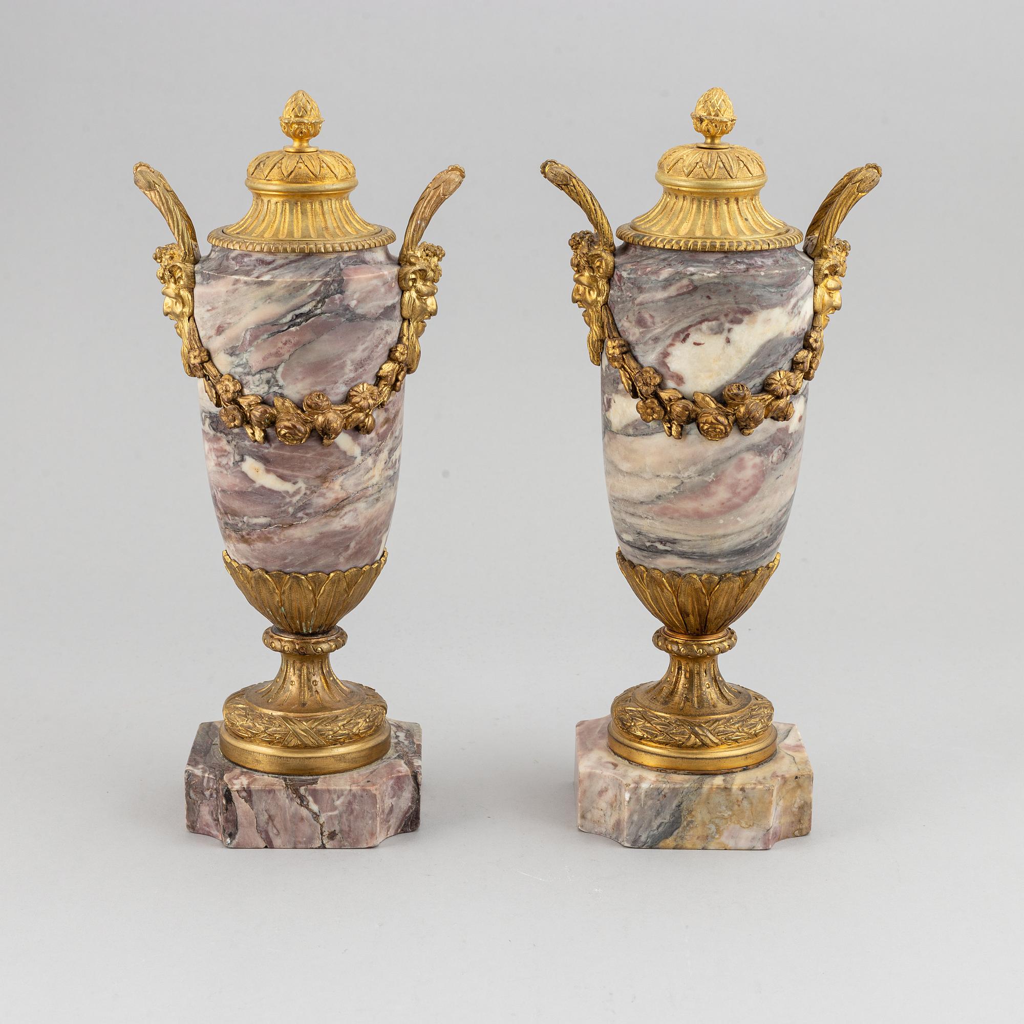 A pair of marble urns with bronze mountings from around year 1900.