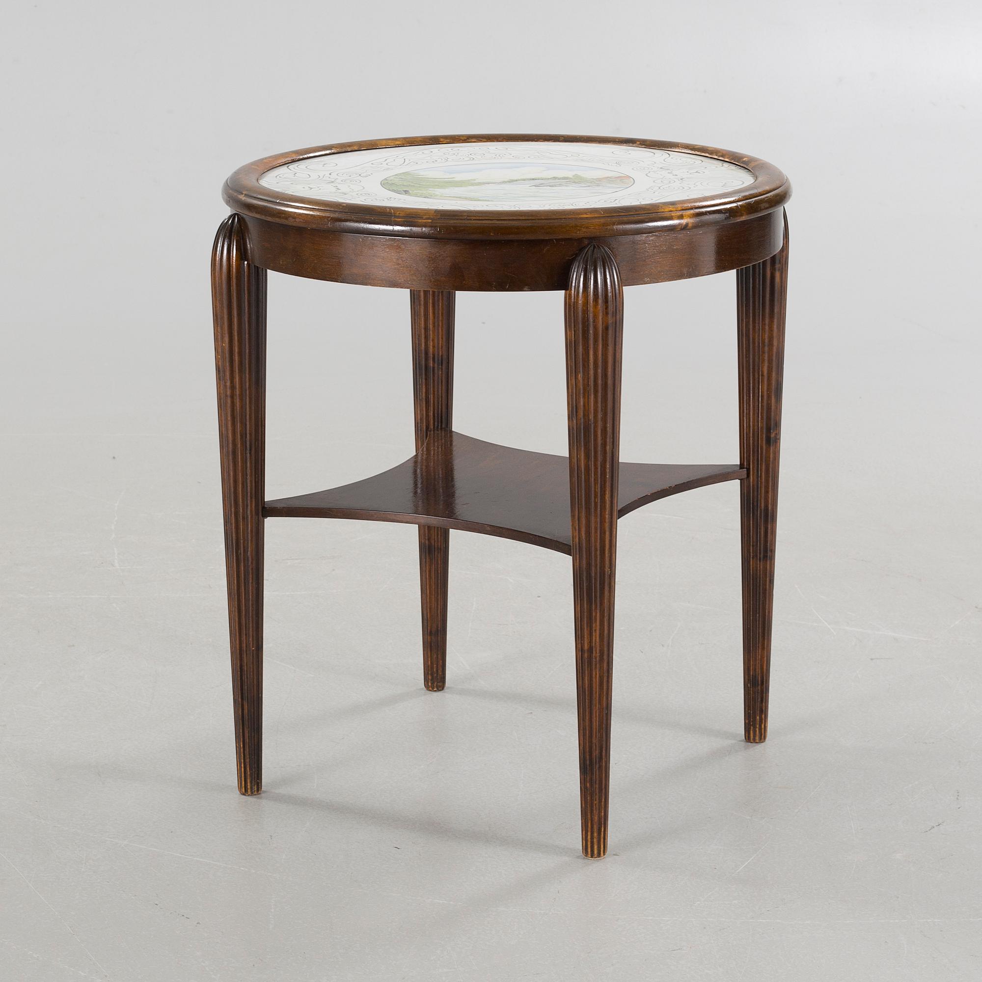 A table from the first halft of the 20th century with a "Kalmar Fajans" tabletop, painted by John Sjöstrand.