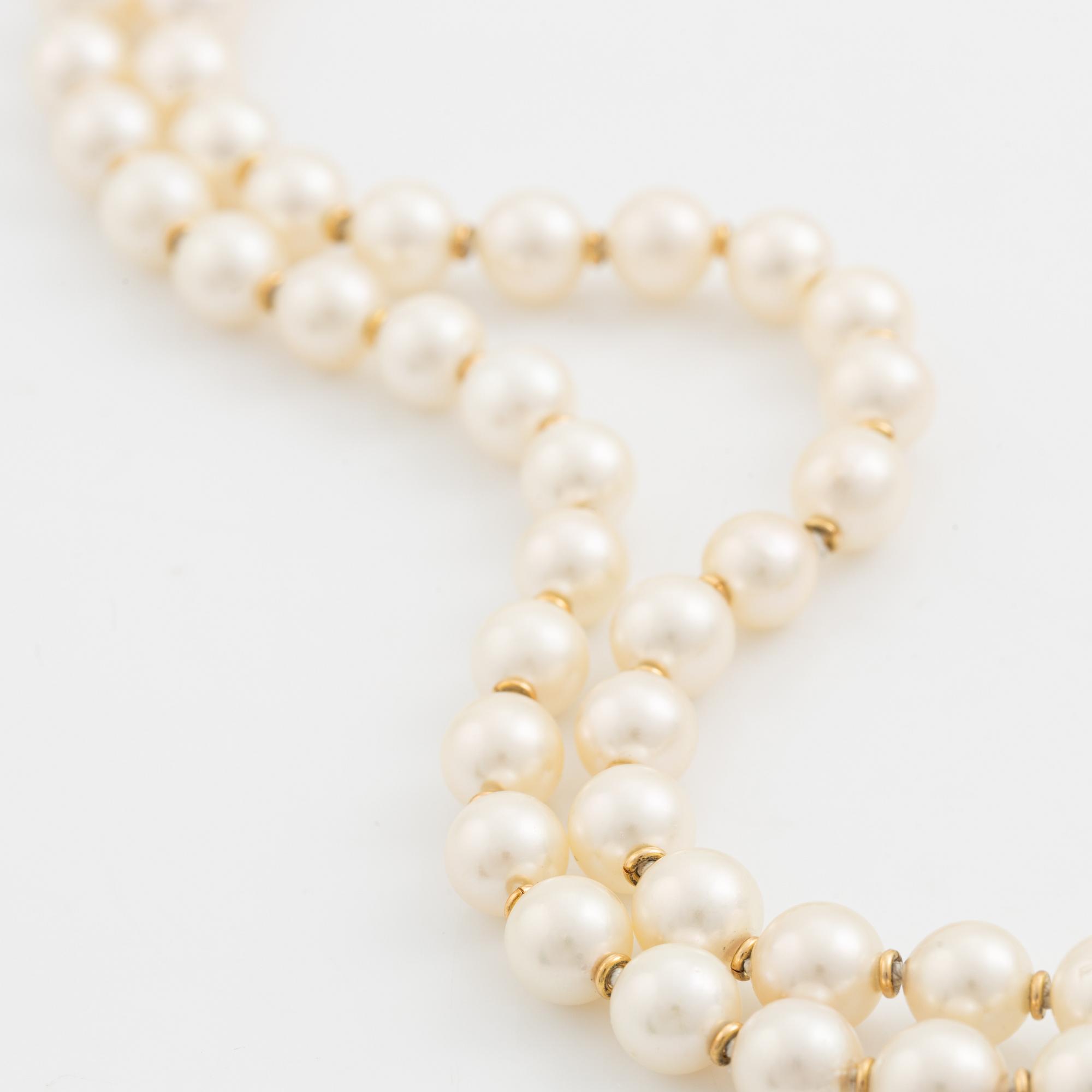 A two strand cultured pearl necklace with an 18K gold clasp with a half-pearl and round brilliant-cut diamonds.