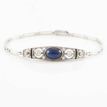A bracelet in platinum set with old-cut diamonds and a blue stone.