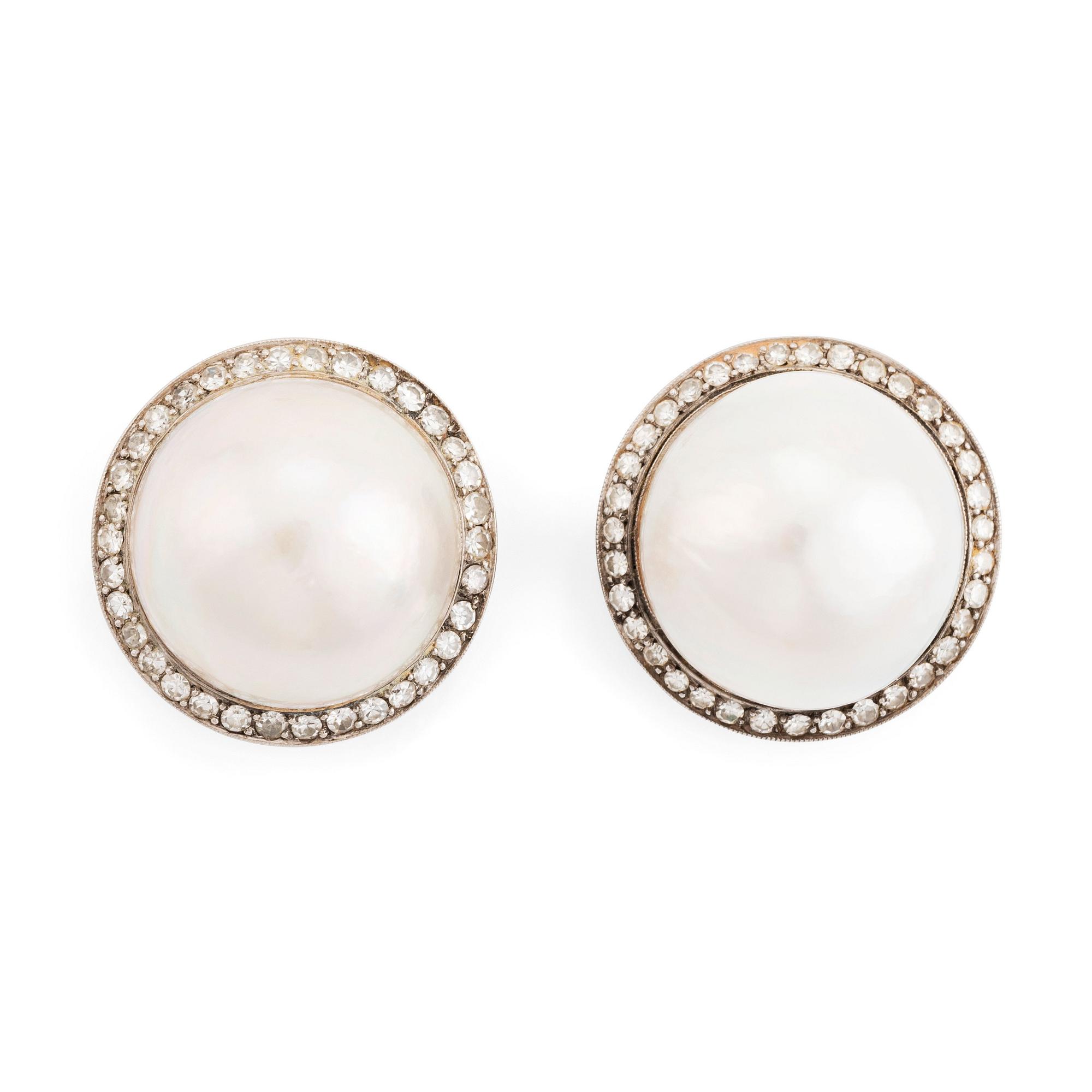 A pair of 18K white gold earrings set with cultured mabe pearls and round brilliant-cut diamonds.