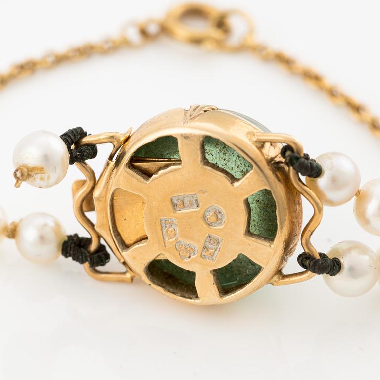 Pearl necklace, double-stranded with graduated cultured pearls, with an 18K gold clasp and cabochon-cut green tourmaline.