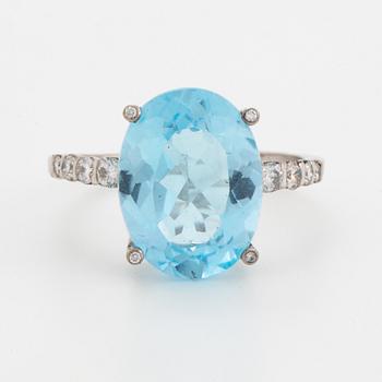 Oval faceted blue topaz and brilliant-cut diamond cocktail ring.