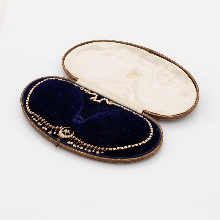 A gold necklace set with pearls.