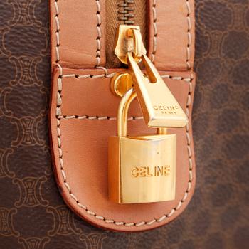 CÉLINE, a brown coated monogram canvas weekend bag.