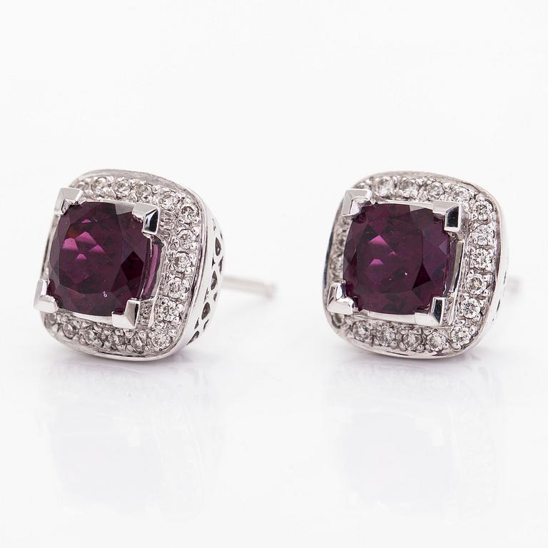 A pair of 14K white gold earrings with diamonds approx. 0.10 ct in total and garnets.