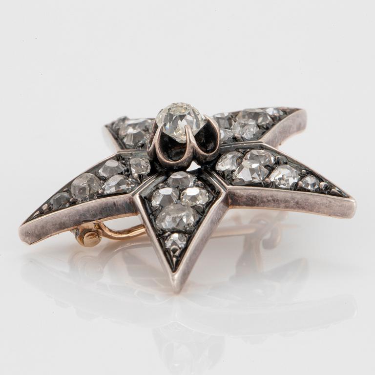 A 14K gold and silver star brooch set with old-cut diamonds.