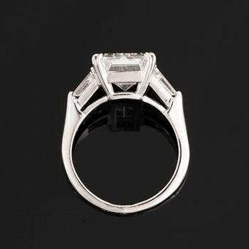 A platinum ring set with an emerald-cut diamond.