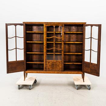 A glass and veneered cabinet from the first half of the 20th century.