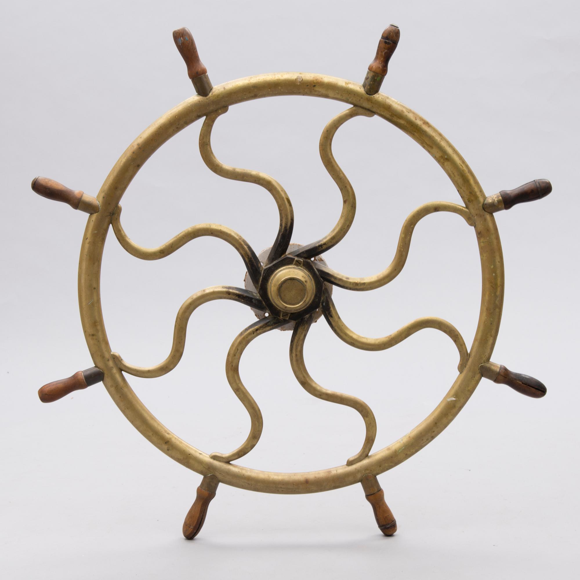 A ship's brass steering wheel, circa 1900.