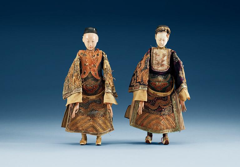 A pair of chinese bisque dolls with silk clothing, Qing dynasty.