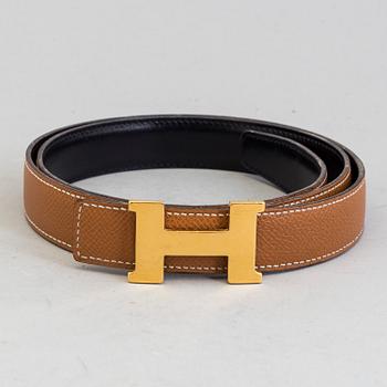 A Hermès "H" belt buckle with reversible leather strap noir/gold.