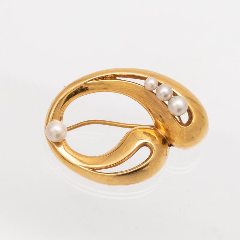 An 18K gold brooch with cultured pearls.