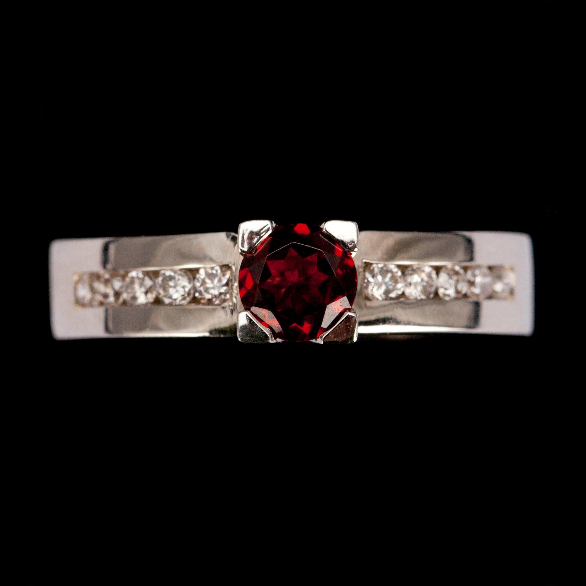 RING, vitguld 14K, fasettslipad granat 0,49 ct, briljantslipade diamanter diamanter tot. 0,21 ct. Vikt 4,7 g.