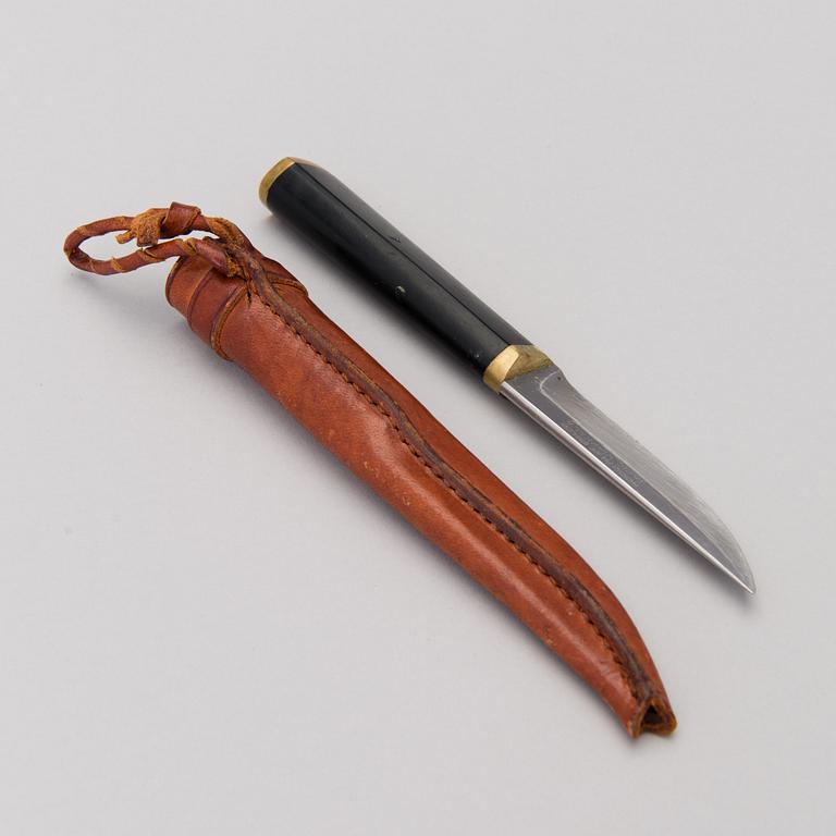 A Finnish puukko knife in stainless steel, nylon and brass designed by Tapio Wirkkala, Hackman Finland.