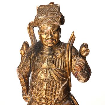 A gilt and lacquered standing figure of a guardsman, Qing dynasty.