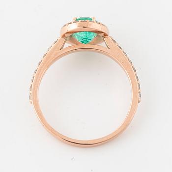 An oval cut emerald and brilliant cut diamond ring.