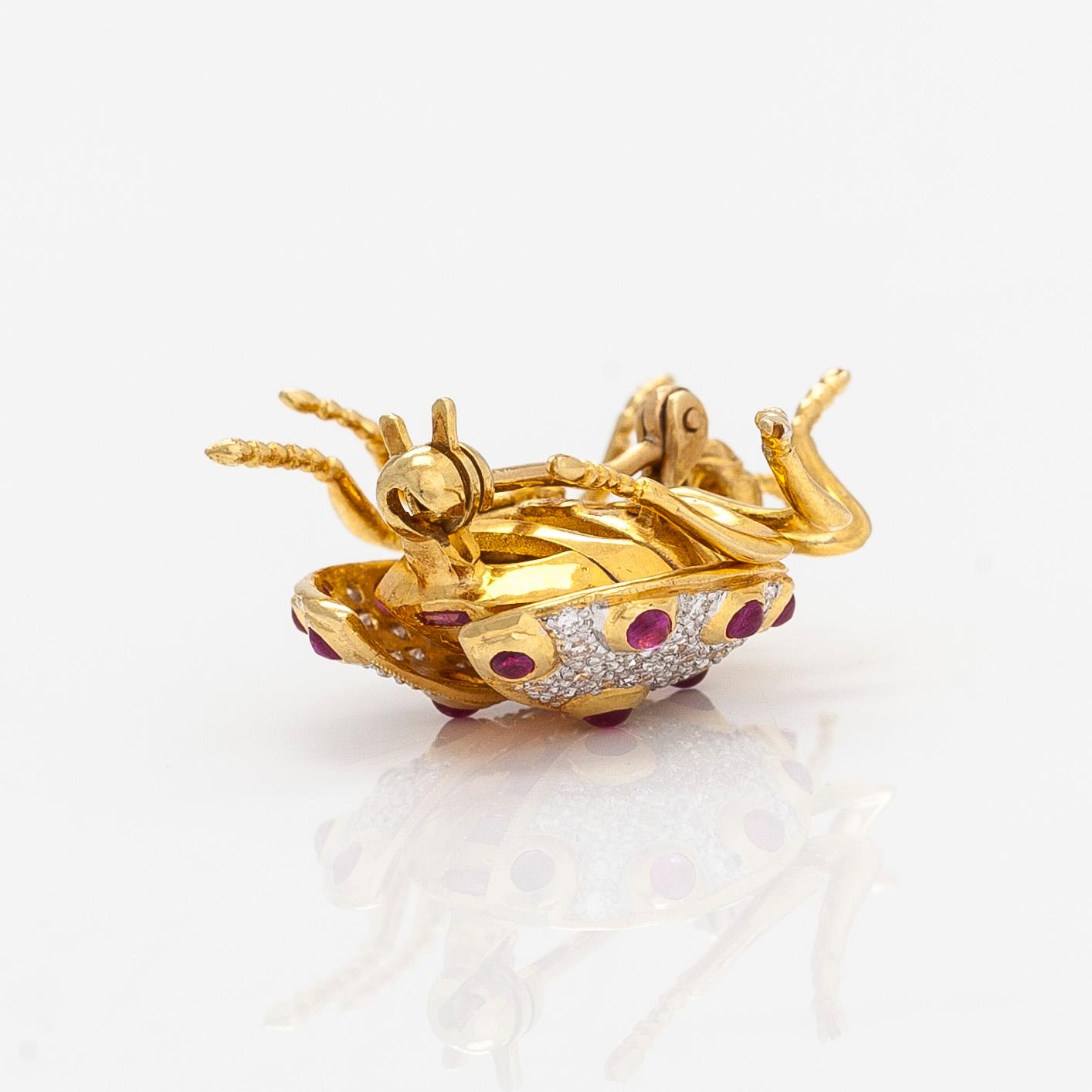 An 18K gold ladybug brooch, with rubies and diamonds.