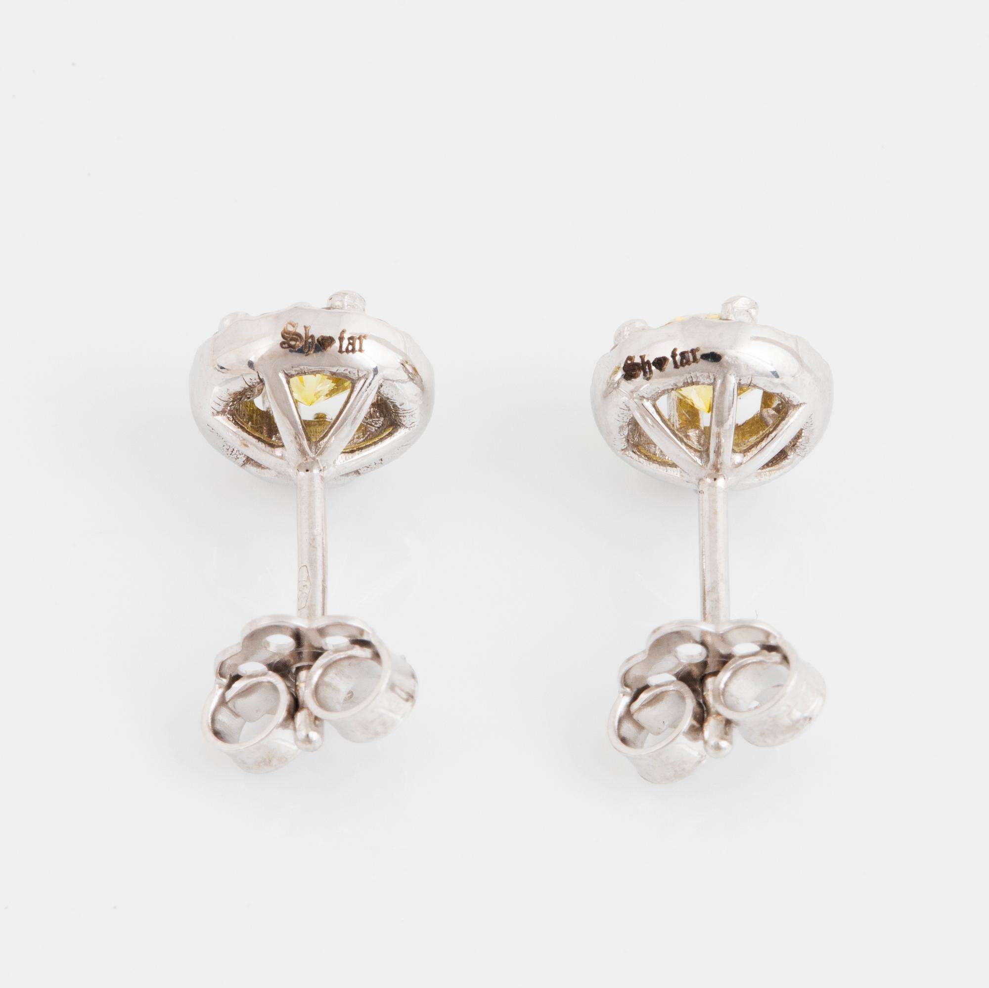 A pair of 18K gold earrings set with color treated yellow diamonds.
