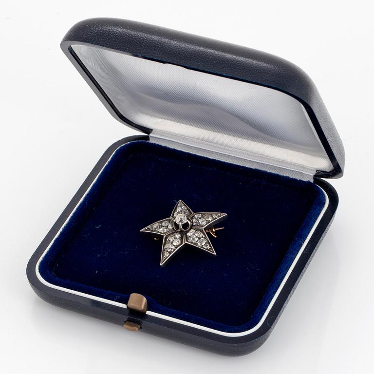 A 14K gold and silver star brooch set with old-cut diamonds.