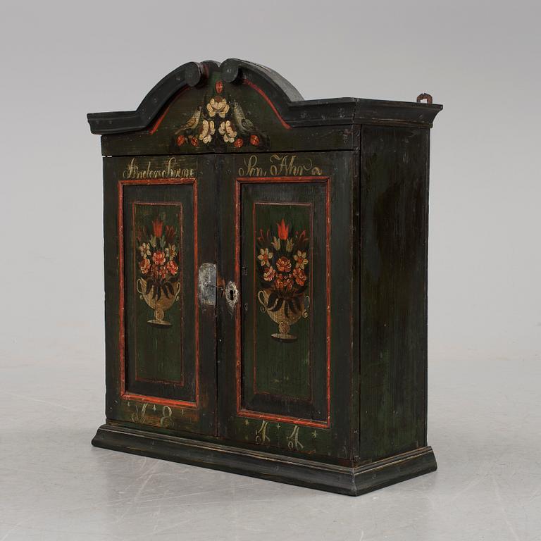 A hanging folk art wall cabinet southern Sweden dated 1844.