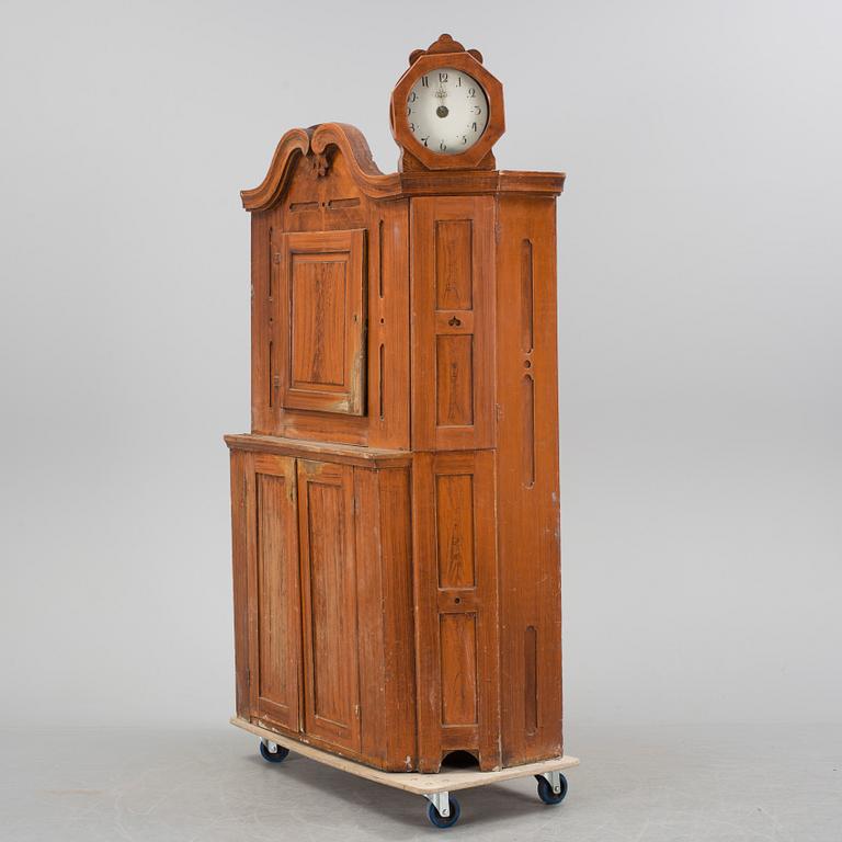 An 18th century cabinet with a clock.