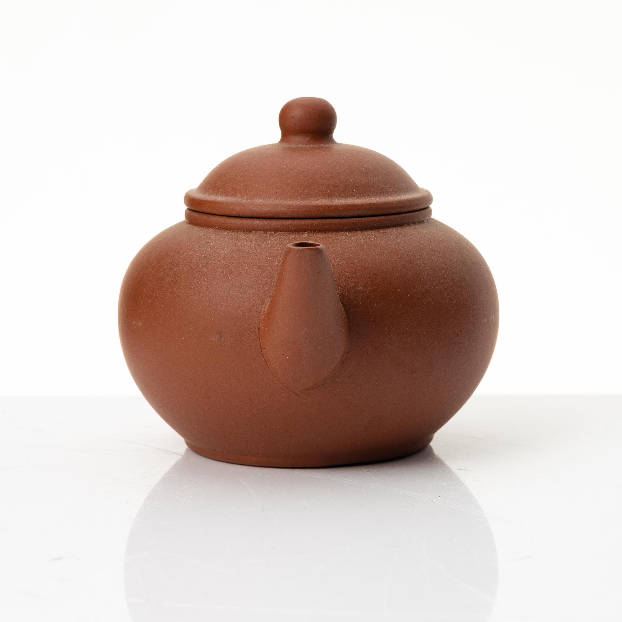 A six part red yixing Gongfu set; teapot, four cups and a tray, China, 1980s.