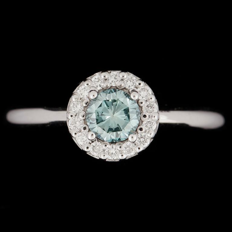RING, 18k vitguld, briljantslipad färgad blå diamant ca 0,52ct samt 14 briljantslipade diamanter tot ca 0,15ct.