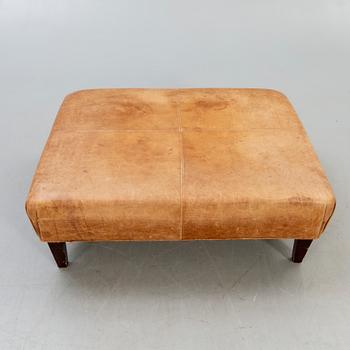 A leather ottoman/coffee table alter part of the 20th century.