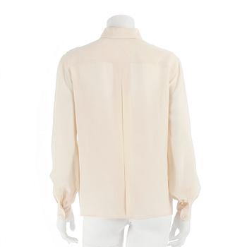 CÉLINE, a créme colored silk blouse.