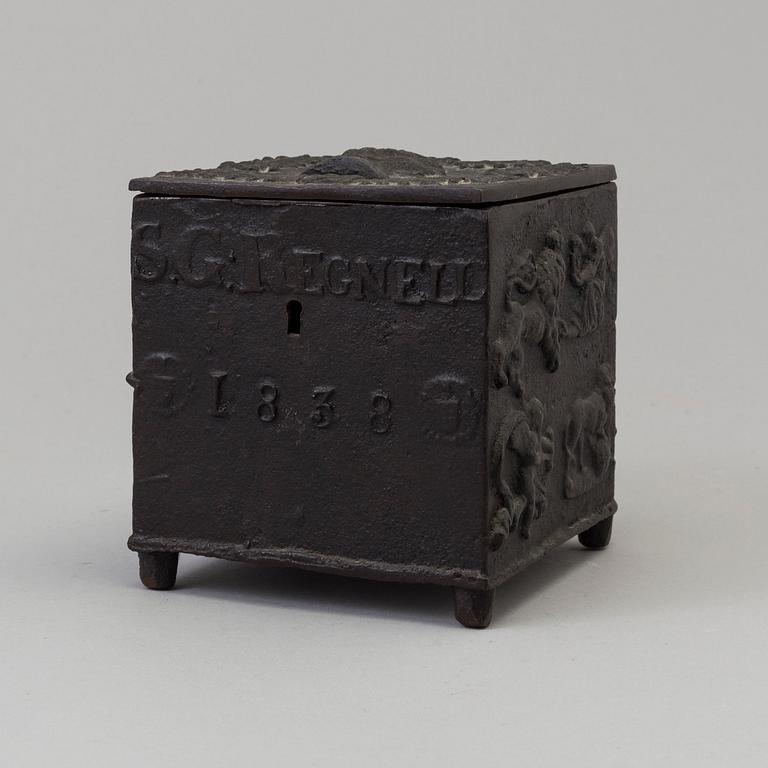 An empire cast iron tobacco box, dated 1838.